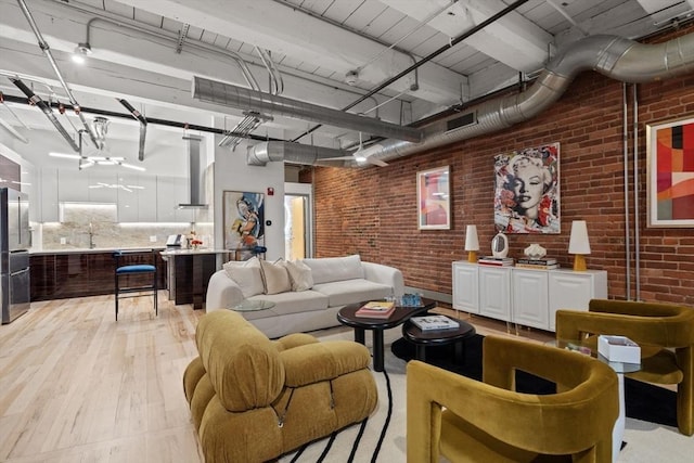 living room featuring light hardwood / wood-style floors and brick wall