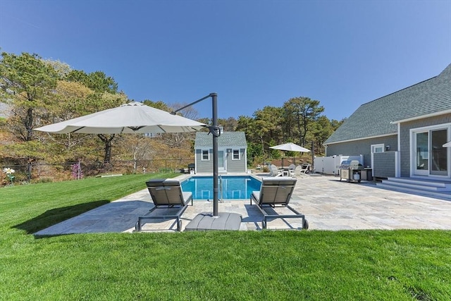 view of swimming pool featuring an outbuilding, a shed, and a patio area