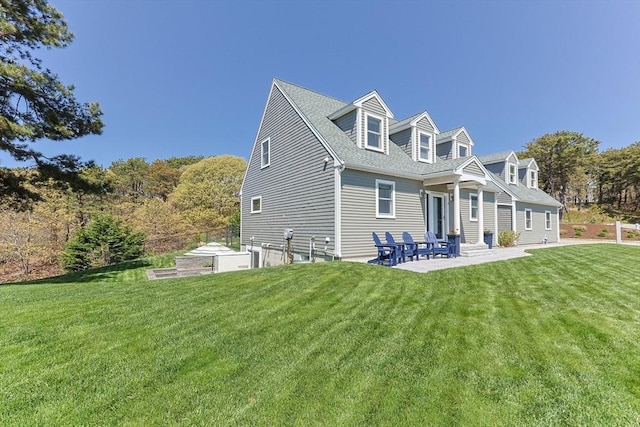 back of property with a yard, a patio, and roof with shingles