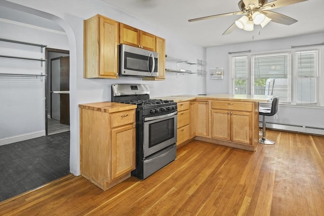 40 By St, Lowell, MA 01850 - kitchen with appliances with stainless steel finishes, a peninsula, light wood finished floors, and a baseboard radiator