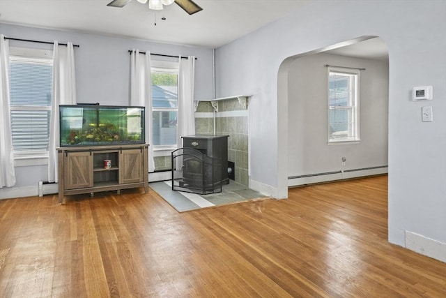 40 By St, Lowell, MA 01850 - living room featuring a baseboard heating unit, arched walkways, a ceiling fan, and wood finished floors