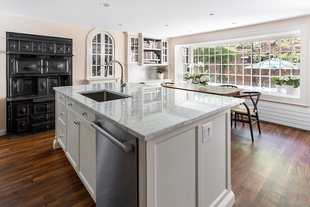 kitchen with a sink, open shelves, a center island with sink, dishwasher, and white cabinetry
