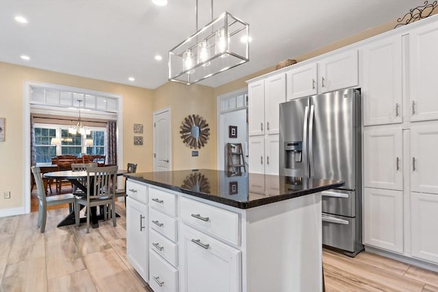 kitchen with a center island, white cabinets, stainless steel fridge with ice dispenser, and recessed lighting