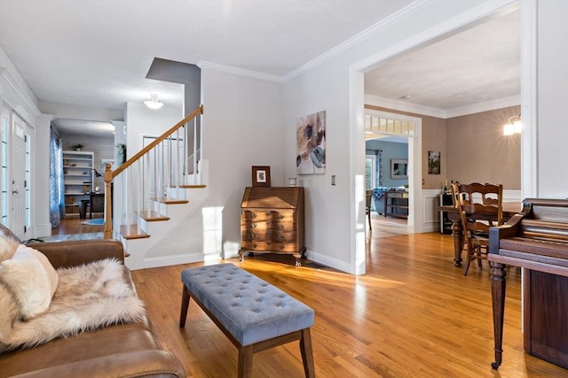 living room with ornamental molding, stairway, light wood-type flooring, and baseboards