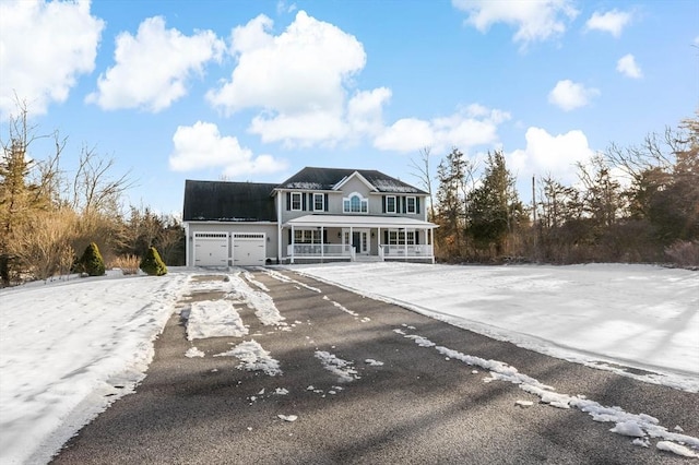 view of front of house featuring covered porch, driveway, and an attached garage