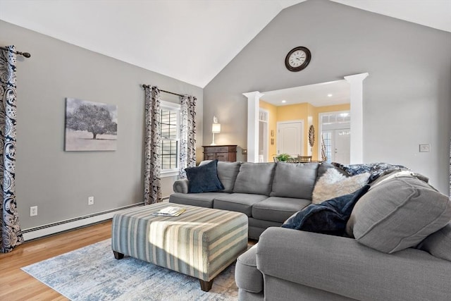 living area featuring high vaulted ceiling, baseboard heating, wood finished floors, and decorative columns