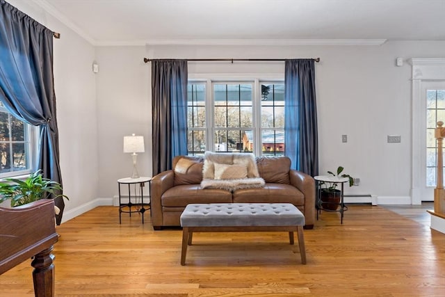 living room with crown molding, light wood-style flooring, and baseboard heating