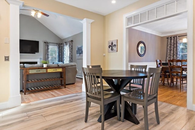 dining area featuring decorative columns, vaulted ceiling, ceiling fan, and wood finished floors