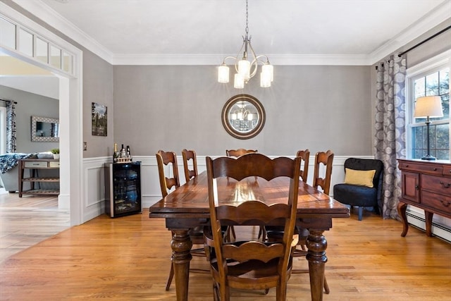 dining area with light wood finished floors, wine cooler, crown molding, and a notable chandelier