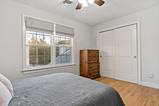 bedroom featuring a closet, visible vents, ceiling fan, wood finished floors, and baseboards