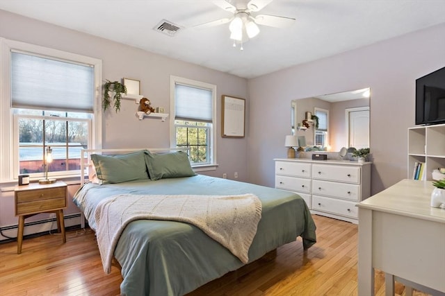 bedroom with light wood finished floors, a baseboard radiator, visible vents, and a ceiling fan