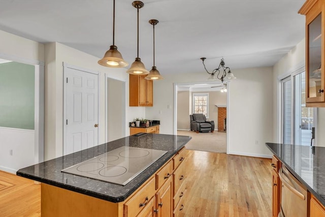 kitchen featuring black electric cooktop, open floor plan, hanging light fixtures, and glass insert cabinets