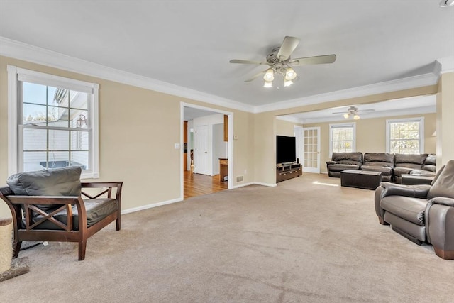 living room with crown molding, a ceiling fan, baseboards, and carpet floors