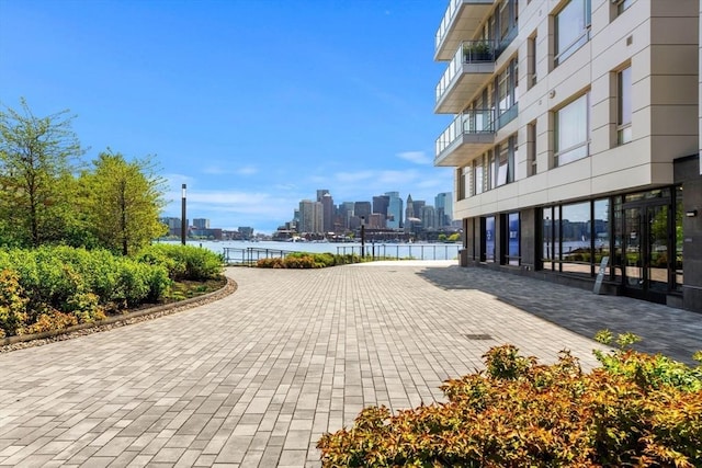 surrounding community with a water view and a view of city