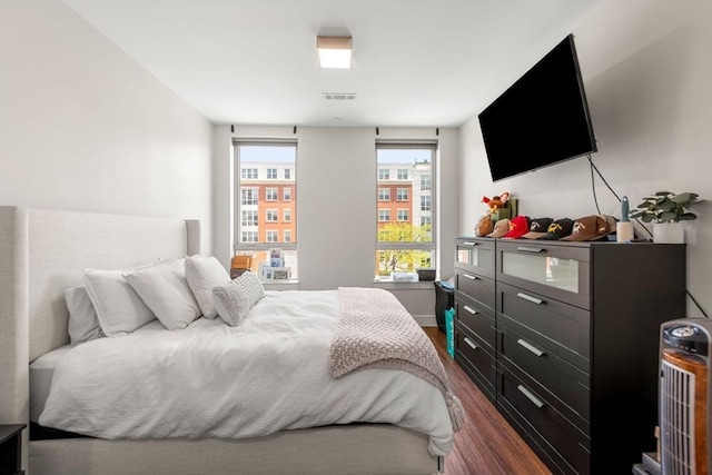 bedroom with dark wood-style floors, baseboards, and visible vents