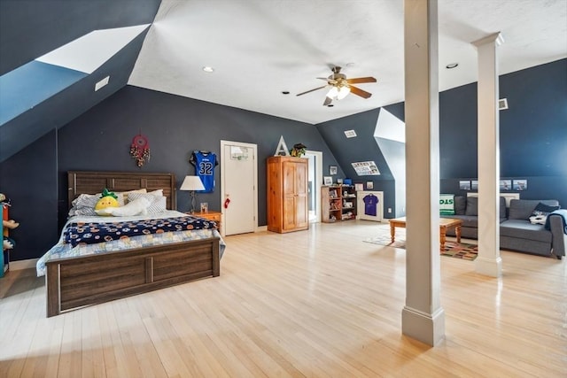 bedroom featuring ornate columns, lofted ceiling, and light hardwood / wood-style flooring