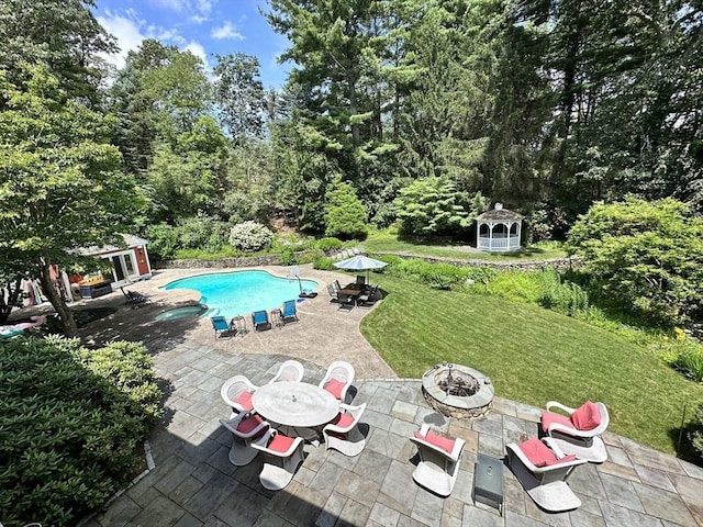 view of pool featuring a gazebo, a patio, an outdoor structure, and a fire pit