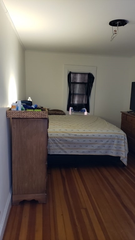 bedroom with crown molding and dark hardwood / wood-style floors