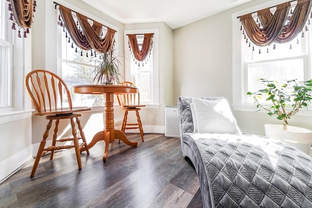 sitting room with baseboards, wood finished floors, an inviting chandelier, and plenty of natural light