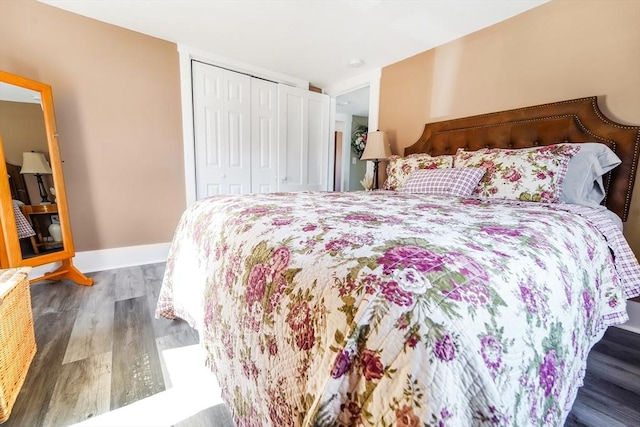 bedroom with baseboards, wood finished floors, and a closet
