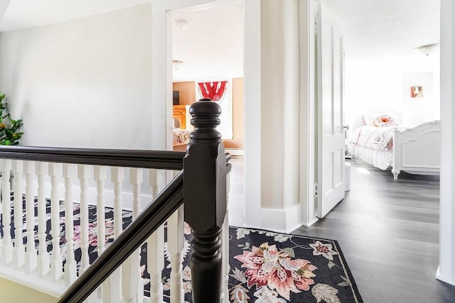 hall featuring dark wood-style flooring and baseboards
