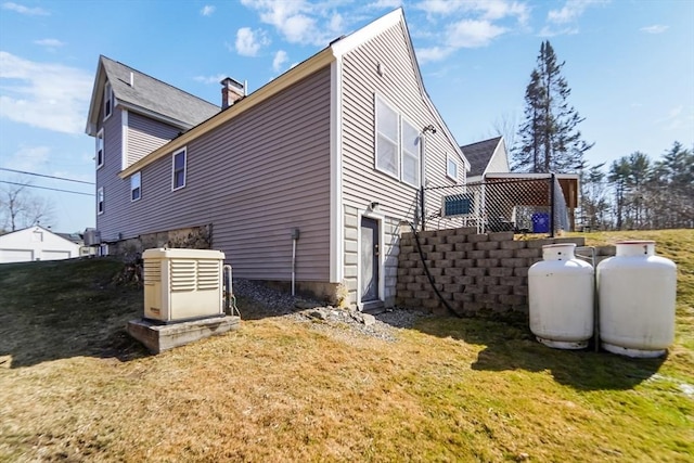 view of home's exterior featuring a lawn and a chimney