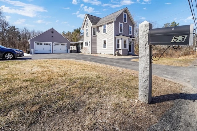 view of property exterior featuring a lawn, a detached garage, and an outbuilding