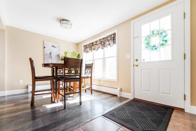 dining area with a baseboard radiator, wood finished floors, and baseboards