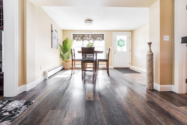 dining space featuring wood finished floors, a baseboard heating unit, and baseboards