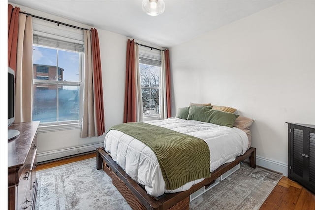 bedroom featuring hardwood / wood-style floors and a baseboard radiator