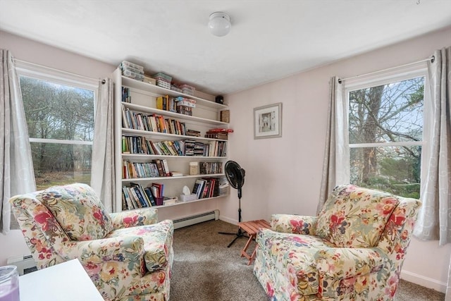 sitting room with baseboards, baseboard heating, carpet floors, and a healthy amount of sunlight