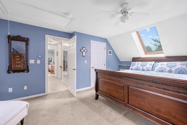 bedroom with attic access, vaulted ceiling, light carpet, and ceiling fan