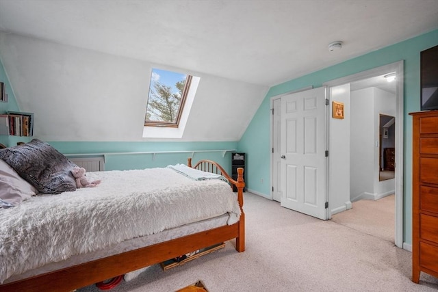 carpeted bedroom with lofted ceiling with skylight and baseboards