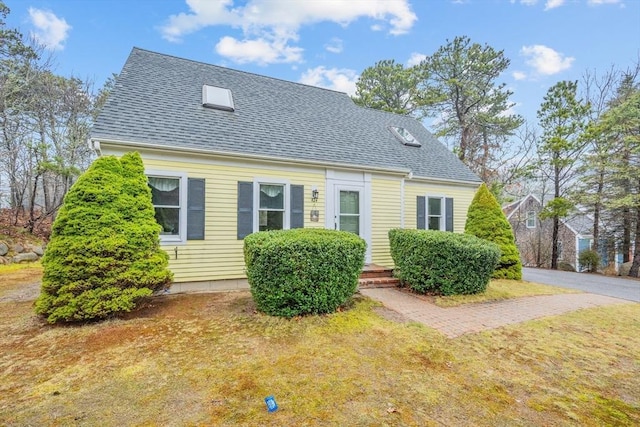 view of front of house featuring a front lawn and roof with shingles