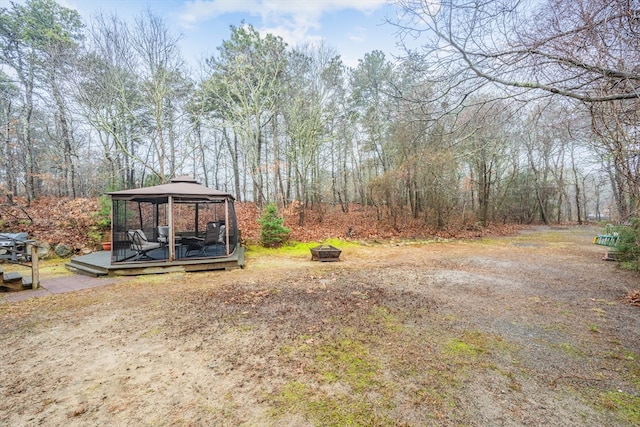 view of yard with an outdoor fire pit, a gazebo, and a deck