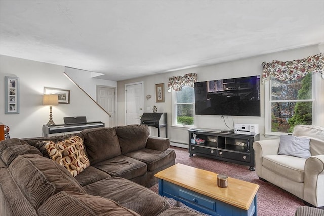 carpeted living room featuring stairs and a baseboard heating unit