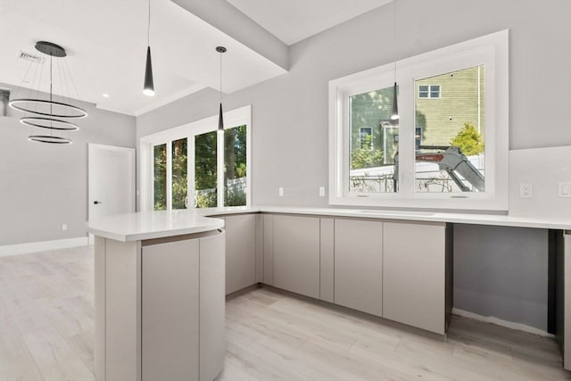 kitchen with a notable chandelier, gray cabinetry, light hardwood / wood-style flooring, and hanging light fixtures