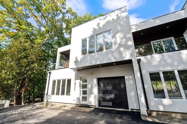 back of house with a balcony and a garage