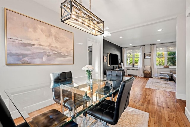 dining area featuring recessed lighting, radiator, wood-type flooring, a chandelier, and baseboards