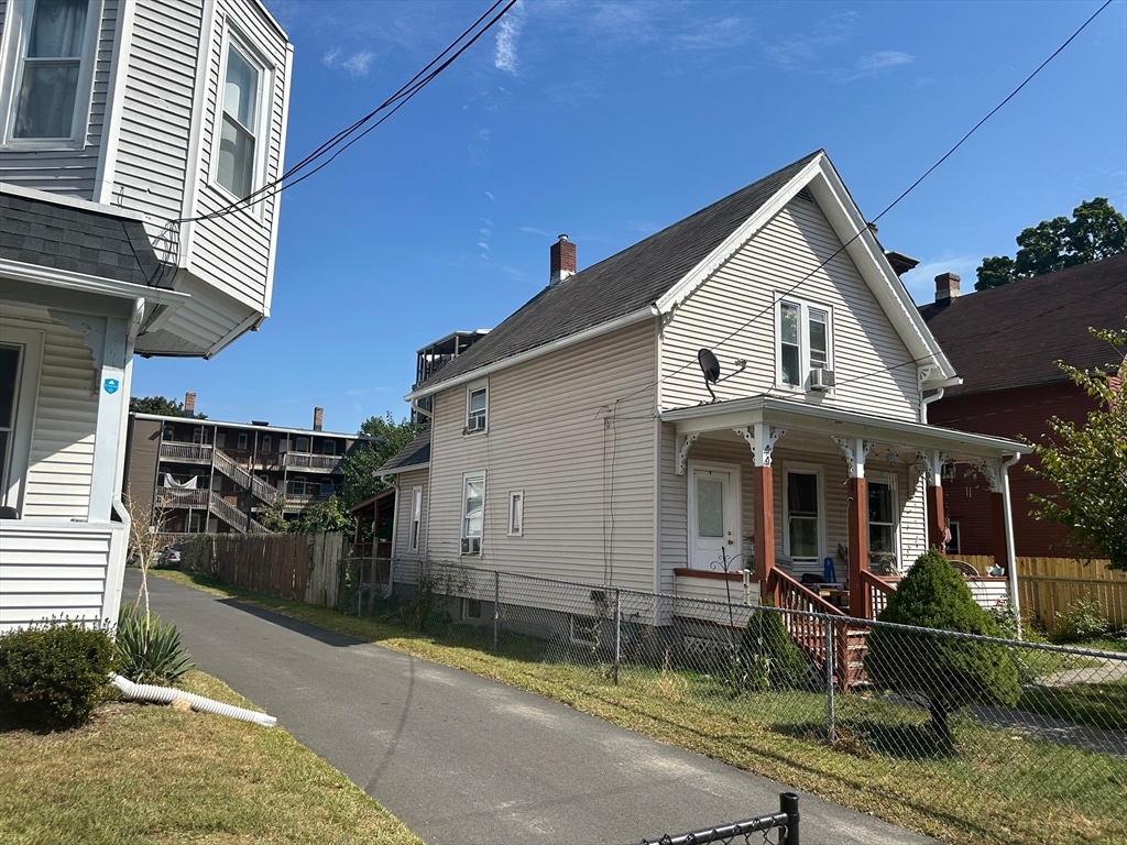 exterior space with a lawn, cooling unit, and a porch