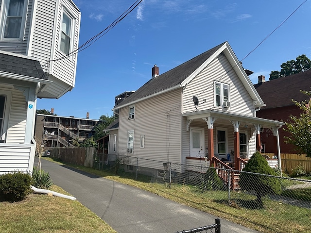 exterior space with a lawn, cooling unit, and a porch