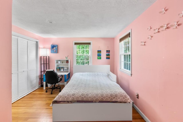 206 Cordaville Rd, Southborough, MA 01772 - bedroom featuring light wood finished floors, a textured ceiling, baseboards, a closet, and an office area