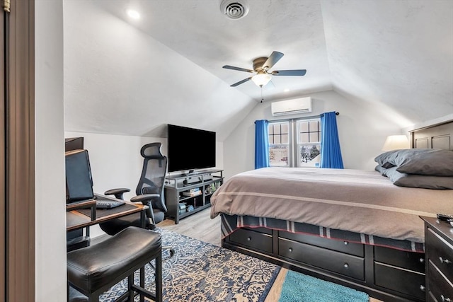 bedroom with ceiling fan, an AC wall unit, lofted ceiling, and light wood-type flooring