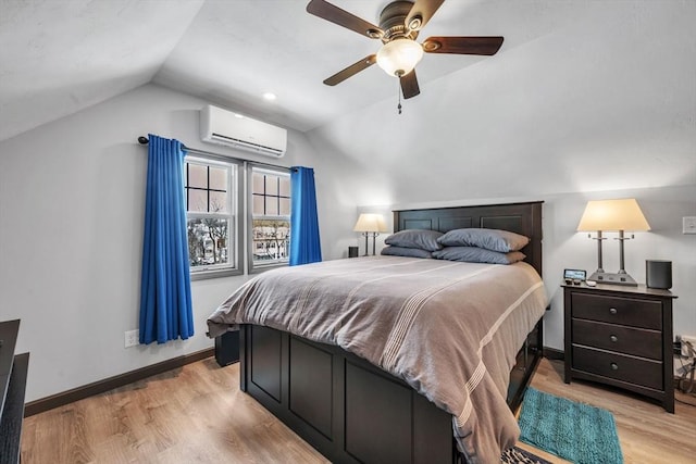 bedroom with ceiling fan, lofted ceiling, light wood-type flooring, and a wall unit AC