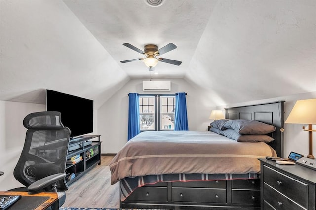 bedroom with lofted ceiling, light hardwood / wood-style flooring, an AC wall unit, and ceiling fan