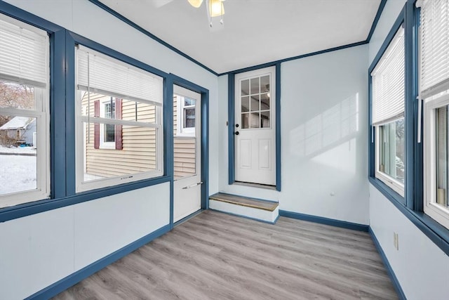 unfurnished sunroom featuring ceiling fan