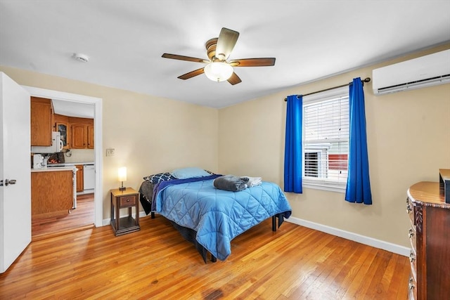 bedroom featuring ceiling fan, a wall mounted air conditioner, and light hardwood / wood-style floors