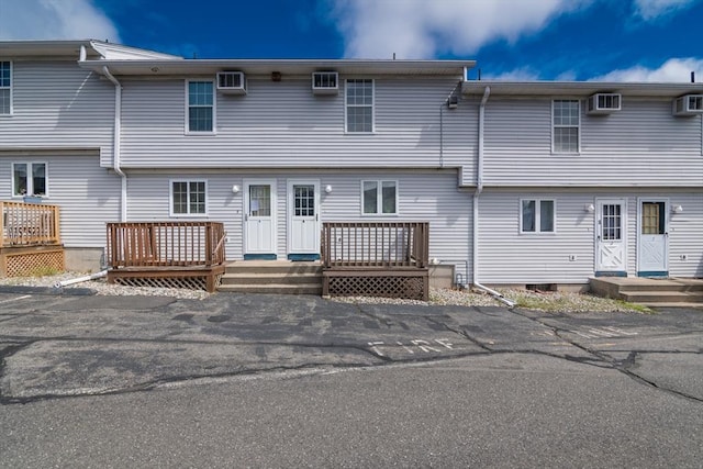 rear view of property with a wooden deck and a wall mounted AC