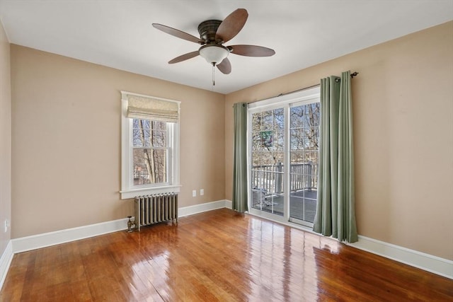 unfurnished room with radiator, plenty of natural light, wood-type flooring, and ceiling fan