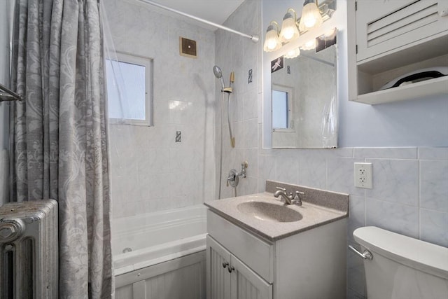 full bathroom featuring a wealth of natural light, radiator, and tile walls